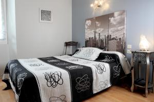ein Schlafzimmer mit einem Bett mit einer schwarzen und weißen Decke in der Unterkunft Hôtel Le Trinquet in Louhossoa