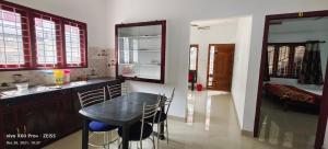 a kitchen with a table and a counter with chairs at Spice Cottage Homestay in Thekkady