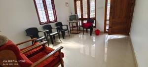 - une salle d'attente avec des chaises et une télévision dans l'établissement Spice Cottage Homestay, à Thekkady