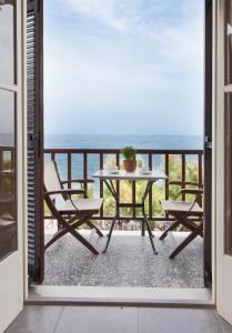 a balcony with a table and chairs and the ocean at Pansion Martha in Agios Ioannis Pelio