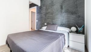 una camera con un letto con una parete grigia di Guest House Roma a Roma