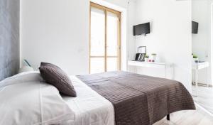 una camera bianca con un letto e una finestra di Guest House Roma a Roma