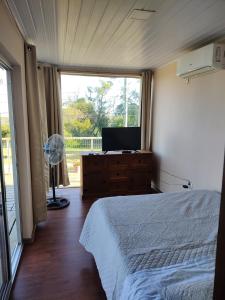 a bedroom with a bed and a tv and a window at Naturaleza pura in Rocha