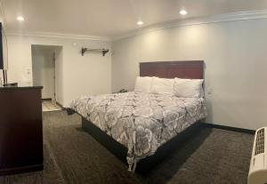 1 dormitorio con 1 cama con cabecero de madera en Capital City Inn Downtown Convention Center en Sacramento