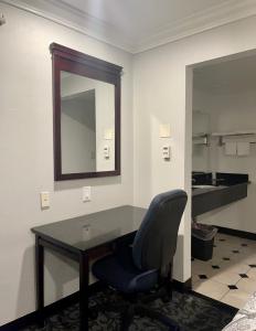 a desk with a chair and a mirror in a room at Capital City Inn Downtown Convention Center in Sacramento