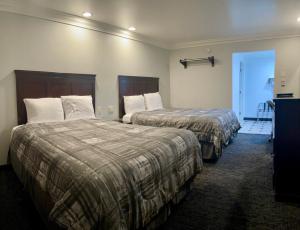 a hotel room with two beds and a hallway at Capital City Inn Downtown Convention Center in Sacramento