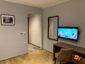 a room with a tv and a chair and a mirror at Point 11 Residence in Dumyāţ