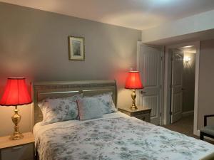 1 dormitorio con 1 cama con 2 lámparas en 2 mesas en Mae Sweet Home, en Surrey