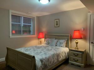 a bedroom with a bed with two lamps and a window at Mae Sweet Home in Surrey