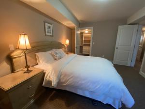Un dormitorio con una gran cama blanca y una lámpara en Mae Sweet Home en Surrey