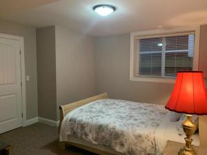 a bedroom with a bed with a lamp and a window at Mae Sweet Home in Surrey