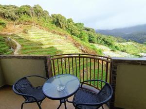 einen Tisch und Stühle auf einem Balkon mit Aussicht in der Unterkunft Dream 2 in Cameron Highlands