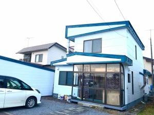 a white car parked in front of a house at Poroto Base ウポポイまで徒歩2分 in Shiraoi