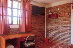a room with a desk and a brick wall at Casa de Descanso Chignahuapan in Chignahuapan