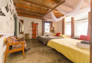 Un dormitorio con 2 camas y una silla. en The Kadupul Homecation, en Da Lat