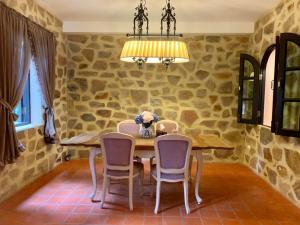a dining room with a table and chairs and a chandelier at Villa Malinee Khao Yai in Ban Tha Chang