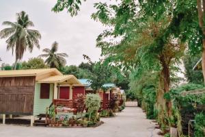 a row of cottages next to palm trees at Ruanmai Style Resort 2 in Ban Nong Nam Khan