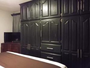 a bedroom with black cabinets and a bed at Hotel Suites La Fortuna in Mazamitla