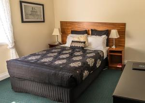 a bedroom with a large bed with a wooden headboard at Stanley Hotel in Stanley +5 photos