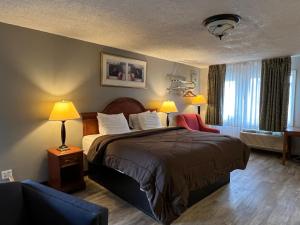Un pat sau paturi într-o cameră la Ozark Inn & Suites