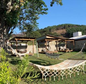 a hammock in front of a house with a boat at Aconchego do Sereno Exclusive Chales in Urubici