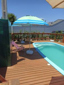 patio con ombrellone e piscina di Sevenresidence a Barra Velha