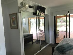 um quarto com uma cama e uma porta de vidro deslizante em Noosa Lake Weyba em Weyba Downs