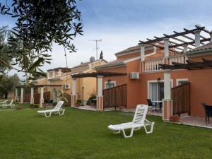 a yard with two lawn chairs and a house at L'eremo Luxury Messonete in Roda