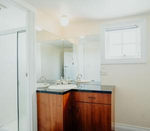 a bathroom with two sinks and a large mirror at Stanley Hotel & Apartments in Stanley