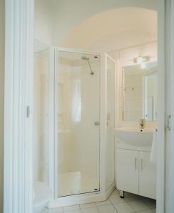 a white bathroom with a shower and a sink at Stanley Hotel in Stanley