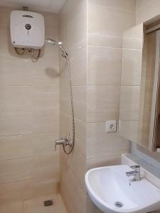 y baño con lavabo y ducha. en Apartement Springwood By LiviRooms Tangerang en Warungmangga