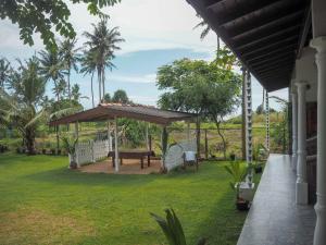 een paviljoen met een picknicktafel in een tuin bij Beach Corner Weligama in Weligama