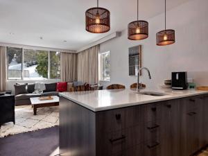 a kitchen with a sink and a living room at KoKo Nanook Squatters 15 in Thredbo
