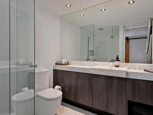 La salle de bains est pourvue de toilettes, d'un lavabo et d'un miroir. dans l'établissement KoKo Nanook Squatters 15, à Thredbo