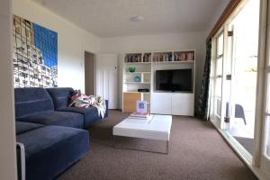 a living room with a blue couch and a coffee table at Muriwai Lodge in Muriwai Beach