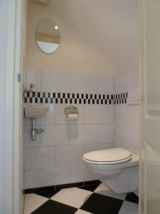 ein Badezimmer mit Toilette und Waschbecken in der Unterkunft Appartement "Zicht op de Vuurtoren" in Noordwijk aan Zee + 35 Fotos