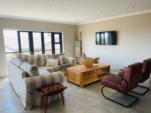 a living room with a couch and a table at Tuscan House in Hartenbos