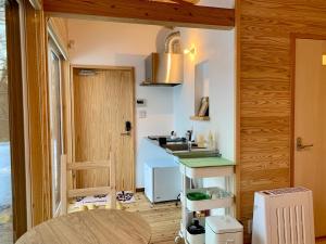 a small kitchen with a sink and a counter at Yatsugatake Little Village Hotel in Hara