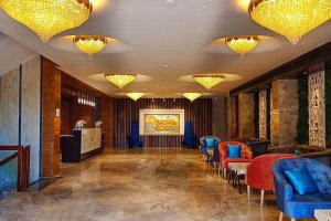 eine Lobby mit Stühlen, einem Tisch und Kronleuchtern in der Unterkunft Howard Johnson by Wyndham Udaipur Roop Nagar in Udaipur