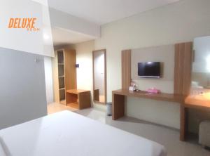 um quarto de hotel com televisão e sala de estar em Wanitatama Villas em Demangan