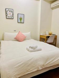 ein Schlafzimmer mit einem weißen Bett und Handtüchern darauf in der Unterkunft 水上雅居民宿 in Hualien