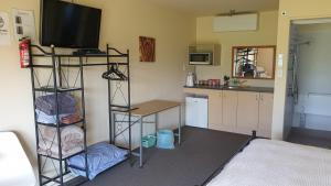 a living room with a kitchen and a room with a television at Bahara Accommodation in Springfield