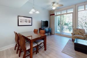 a living room with a dining room table and chairs at Baytowne Wharf - Observation Point North #555 in Destin