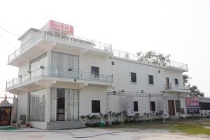 GovardhanGURU KRIPA GARDEN的白色的建筑,上面有标志