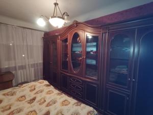 ジェルジンスクにあるУютная 2-х комнатная квартира с мебелью и техникойのベッドルーム(木製キャビネット、ベッド付)