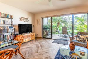 a living room with a tv and a couch and a table at Maui Kamaole M104 in Wailea