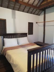 a bedroom with a large bed with a wooden headboard at Banpainamhomestay in Ban Huai Thalaeng Phan