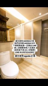 a bathroom with a toilet and a wall with writing at Original Bnb in Tainan