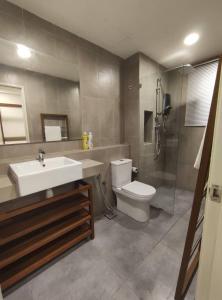 a bathroom with a sink and a toilet and a shower at TimurBay Seafront Holiday Pool & Seaview in Kuantan