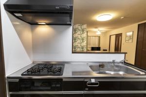 una cocina con estufa y fregadero en Ocean Front Maezato, en Ishigaki Island